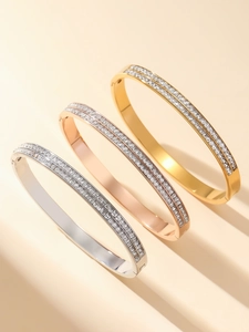 Detailed view of rhinestone bangles in gold, rose gold and silver finishes with zircon