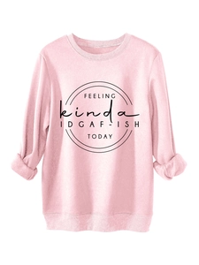 Detail of pink crewneck sweatshirt featuring IDGAF-ISH quote and ribbed cuffs texture