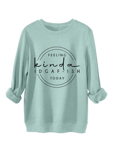 Detail of mint green sweatshirt with IDGAF-ISH text print and ribbed cuffs for casual style