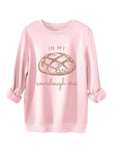 Gros plan sur l'imprimé IN MY sourdough era et le motif pain sur le sweat rose