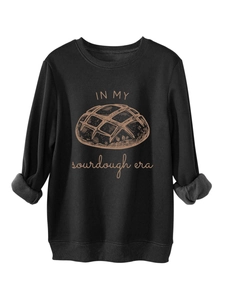 Détail des poignets côtelés et du motif Sourdough Era sur un sweat-shirt noir