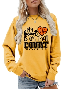 Close-up of basketball heart print and lettering on ginger oversized sweatshirt