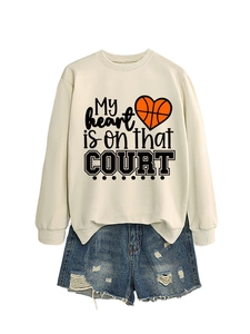 Detail of a beige oversized sweatshirt with heart basketball print and ripped denim shorts