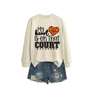 Beige oversized sweatshirt with heart basketball print paired with distressed denim shorts