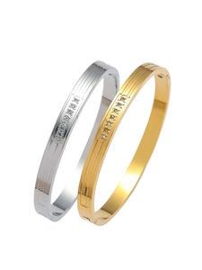 Macro detail of ribbed titanium steel bangles with round zircon stones in gold and silver