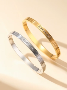 Detail of 18K gold and silver ribbed bracelets with inlaid white zircon stones