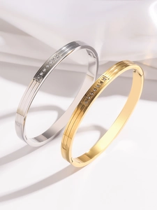 Detail of 18K gold and silver ribbed bangles with inlaid white round cubic zirconia
