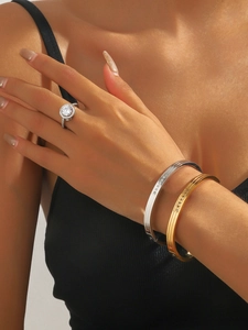 Close-up of 18K gold ribbed bangles with white zircon stones on a female model