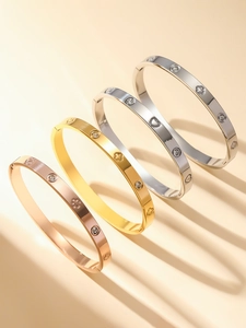 Détail de quatre bracelets en acier inoxydable avec motifs trèfle et cœur en couleurs mixtes