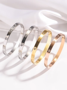Détail de bracelets trèfle en acier inoxydable en finitions argent, or et or rose poli