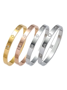 Détail macro de bracelets en acier titane avec motif trèfle et diamètre de 6,5 cm