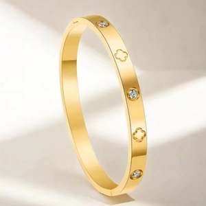 Vue détaillée du bracelet doré en acier inoxydable avec trèfles et zircons incrustés