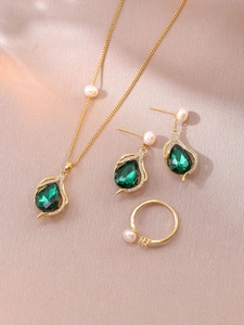 Detail view of freshwater pearl and green teardrop zircon jewelry set with gold finish