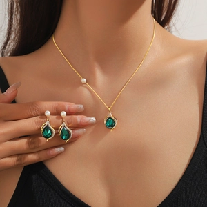 Elegant gold jewelry set with freshwater pearls and emerald green teardrop zircon accents