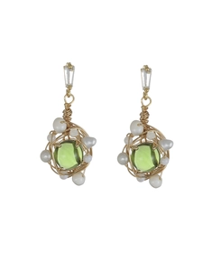 Détail de boucles d'oreilles en fil doré avec pierres vertes et perles d'eau douce
