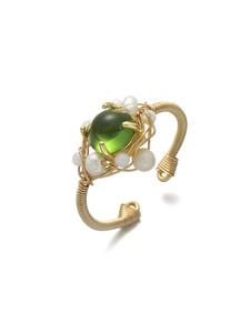Détail d'un bracelet ouvert en fil d'or fait main avec pierre verte et perles blanches
