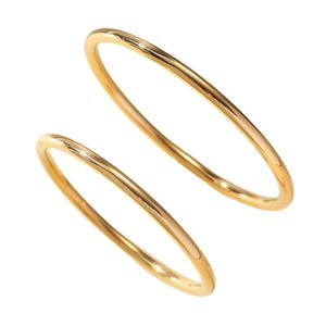 Set de brazaletes minimalistas de acero inoxidable dorado pulido en fondo blanco