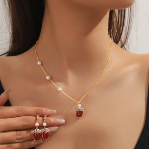 Parure collier et boucles d'oreilles dorés avec fleurs en agate rouge et perles
