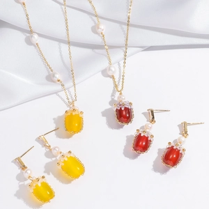 Détail d'un ensemble de bijoux vintage avec agate rouge, perles et dorures