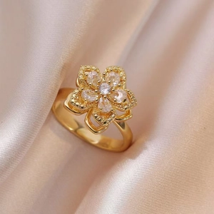 Close-up of a golden flower-shaped ring with marquise and round zircon petals on satin