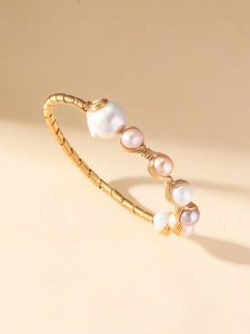 Dettaglio di un bracciale fatto a mano in filo d'oro con perle barocche d'acqua dolce