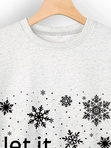 Detail of ribbed crew neck and black snowflake print on light grey sweatshirt