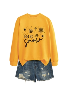 Detailed view of yellow let it snow sweatshirt paired with distressed denim shorts
