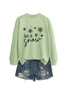 Detail of mint green sweatshirt with 'let it snow' text and distressed denim shorts