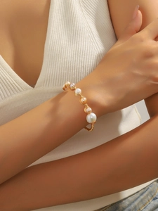 Dettaglio del bracciale fatto a mano in filo dorato con perle barocche colorate