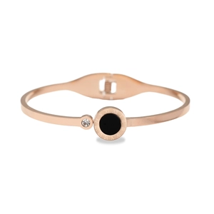 Detail of rose gold bangle with roman numerals, black inlay, and cubic zirconia stone