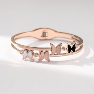 Détail du bracelet double couche en or rose avec papillons en émail et cristaux brillants