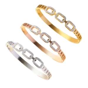 Trois bracelets en acier inoxydable avec strass et découpes en finitions or, argent et or rose