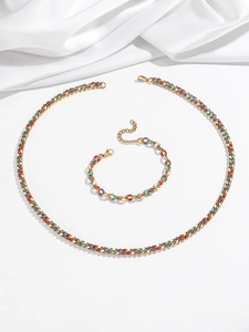 Détail des breloques en émail coloré sur l'ensemble collier en acier doré cubain