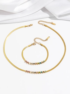 Detail of gold snake chain necklace and bracelet set with colorful round cubic zirconia stones