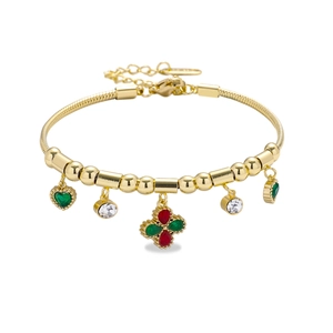 Détails d'un bracelet chaîne serpent doré avec cœur vert et pendentifs gemmes