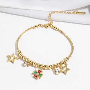 Détail macro d'un bracelet maille serpent doré avec breloques étoiles et trèfle serti