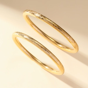 Detail of vintage gold plated titanium steel bangles with Fu character engravings