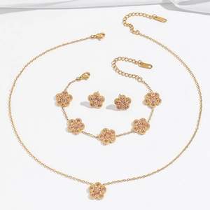 Elegant 18K gold-plated jewelry set featuring pink crystal clover necklace, bracelet, and earrings