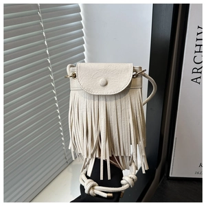 Detail of cream tassel crossbody bag with woven rope strap and minimalist round buckle