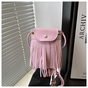 Detail of light pink crossbody bag with long tassels and minimalist faux leather flap cover