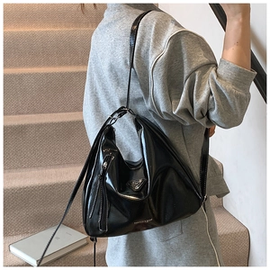 Vue détaillée du sac cabas en cuir verni noir avec logo métallique triangulaire