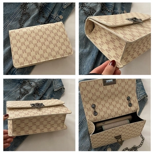 Detail view of beige monogram crossbody bag with chain strap and magnetic closure