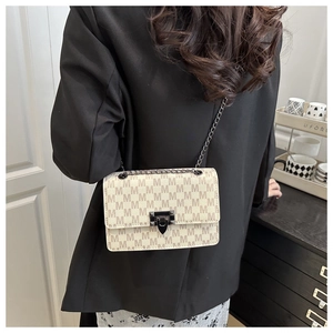 Detail view of beige monogram chain bag with gunmetal clasp and textured PU leather