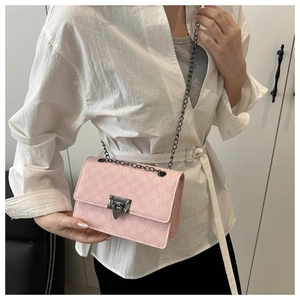 Detail of light pink monogram small square bag with dark metal chain and lock