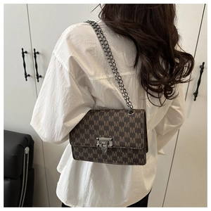 Detail of vintage brown chain bag with M-pattern monogram and metal press buckle
