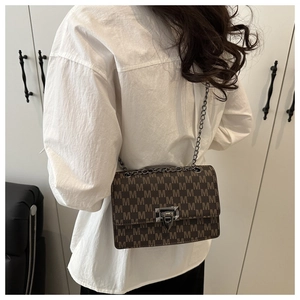 Detail view of stylish crossbody square bag with M-pattern print and metal chain strap