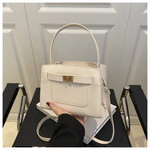 Detail of cream Saffiano tote bag with gold twist lock and structured cross-body strap