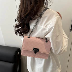 Chic light pink chain crossbody bag with metal lock shown as side view on a model