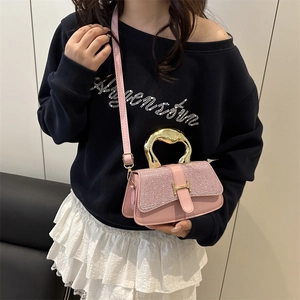 Schicke rosa Handtasche mit Glitzerklappe und Goldgriff, getragen von einem Modell