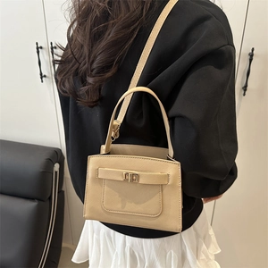 Minimalist beige crossbody square bag with gold turn-lock and adjustable shoulder strap
